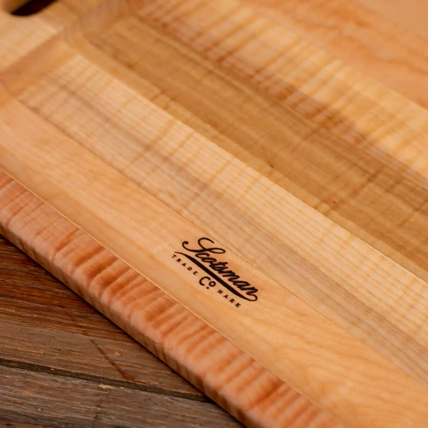 Curly Maple Barbecue Board. Close up of Scotsman logo.