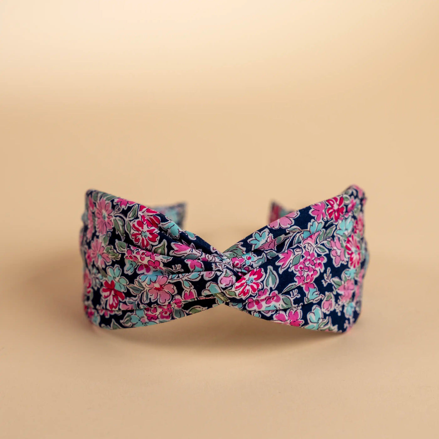 Lucys Navy Poppy Floral Headband. Dark navy background with pink and blue flowers. Front view. 