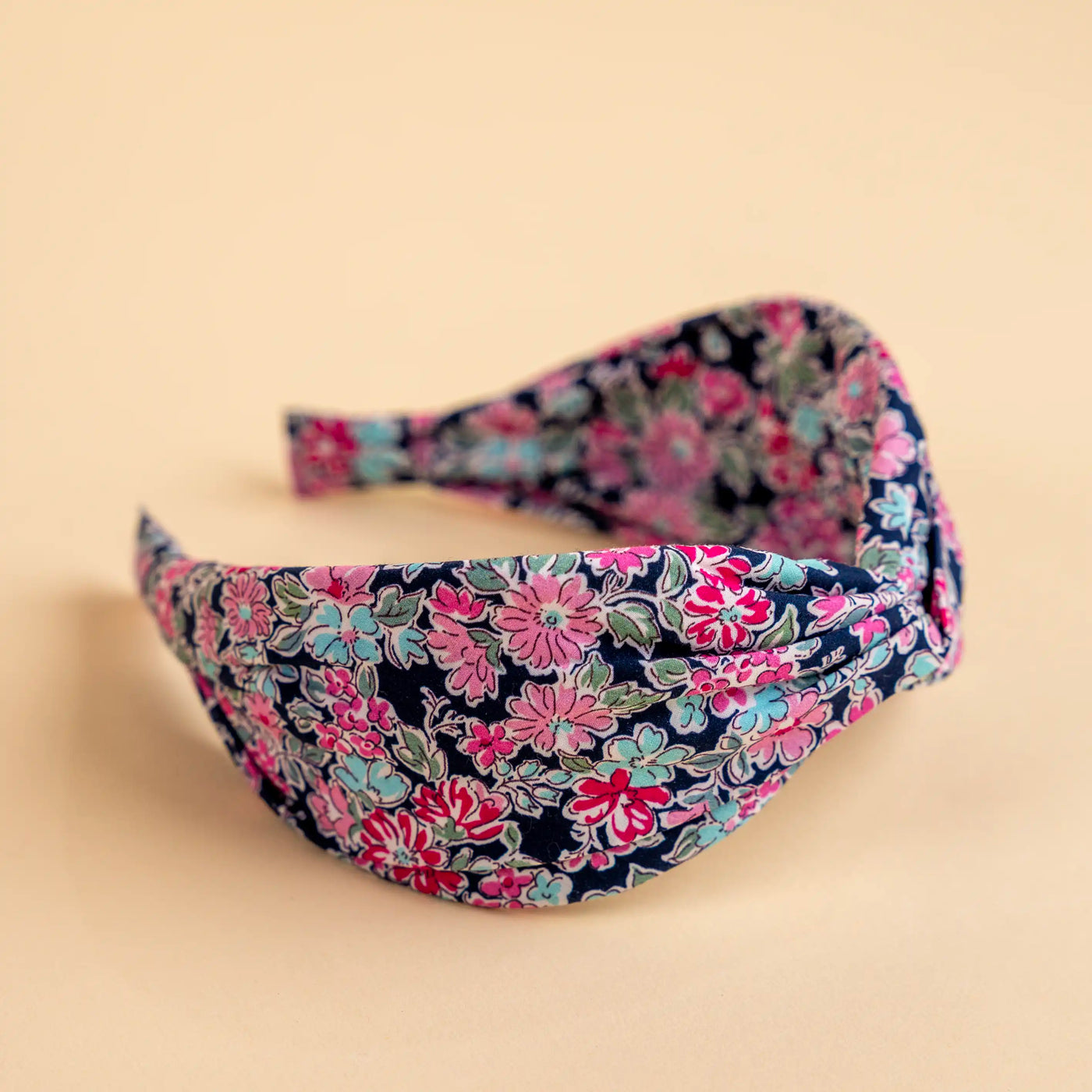 Lucys Navy Poppy Floral Headband. Dark navy background with pink and blue flowers. Side view.