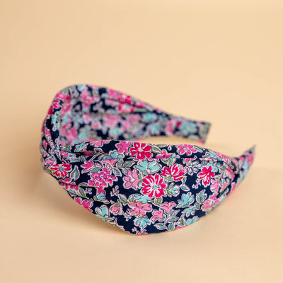 Lucys Navy Poppy Floral Headband. Dark navy background with pink and blue flowers. Side view.