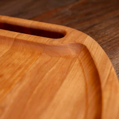 Cherry Oval Barbecue Board. Close up of raised edge.