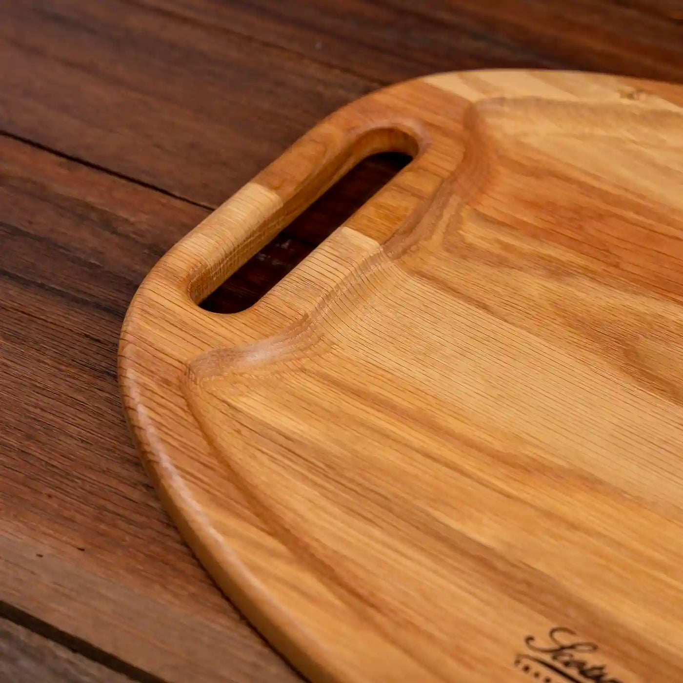 White Oak Oval Barbecue Board. Close up of handle and raised edge.
